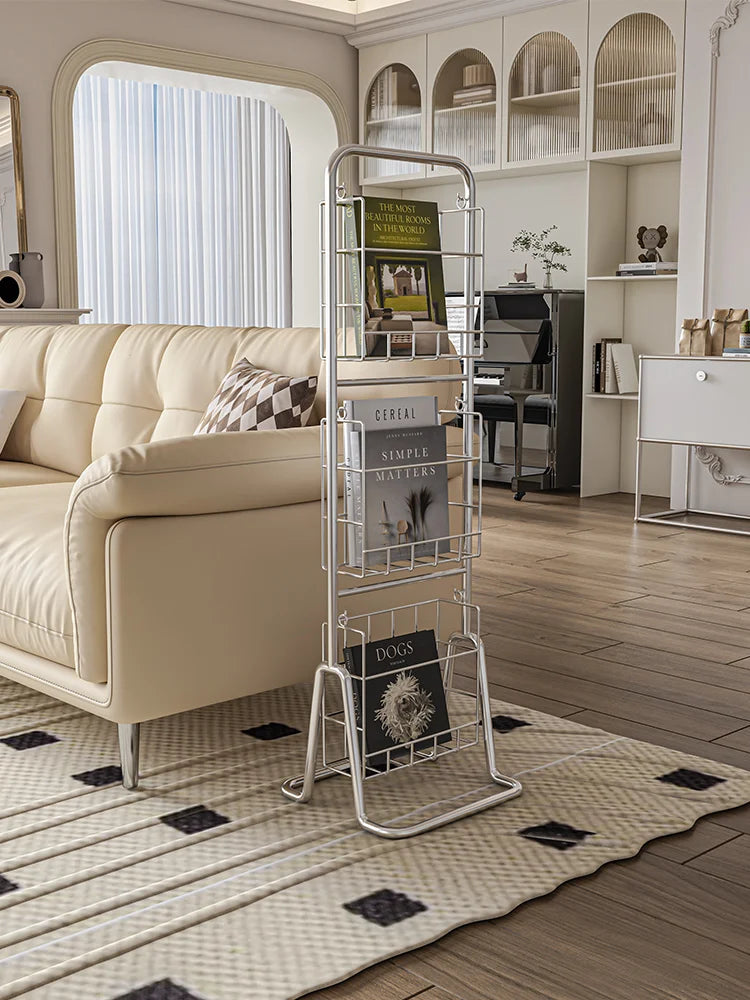 Metal magazine rack in a living room with a beige sofa and decorative items.