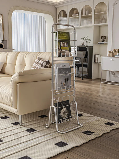 Metal magazine rack in a living room with a beige sofa and decorative items.