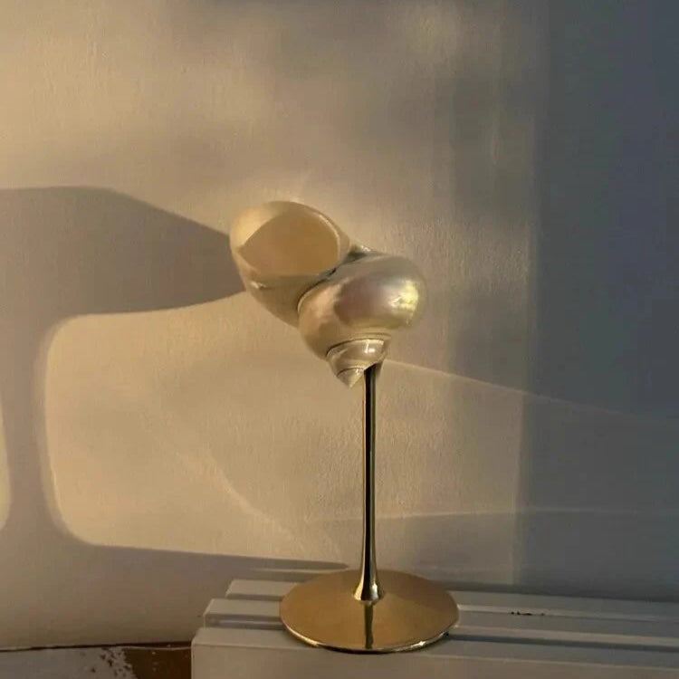 Gold decorative object on a white surface with a neutral background