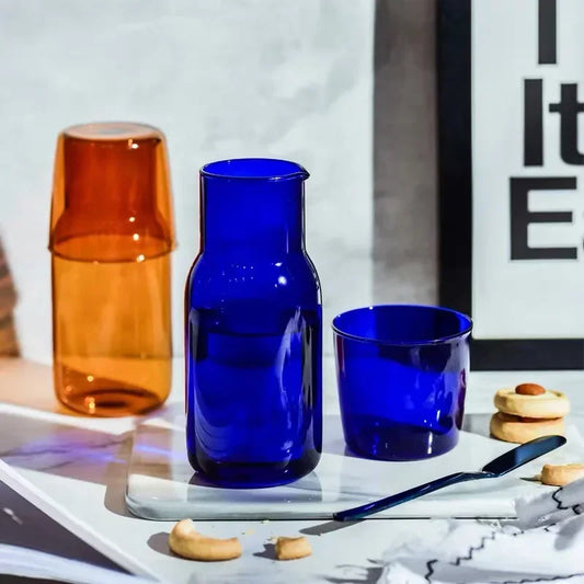 Blue glass carafe and cup on a table with a blurred background