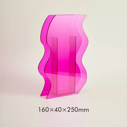 A pink, wavy acrylic vase on a white background