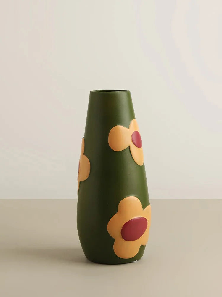 Green vase with floral designs on a beige background