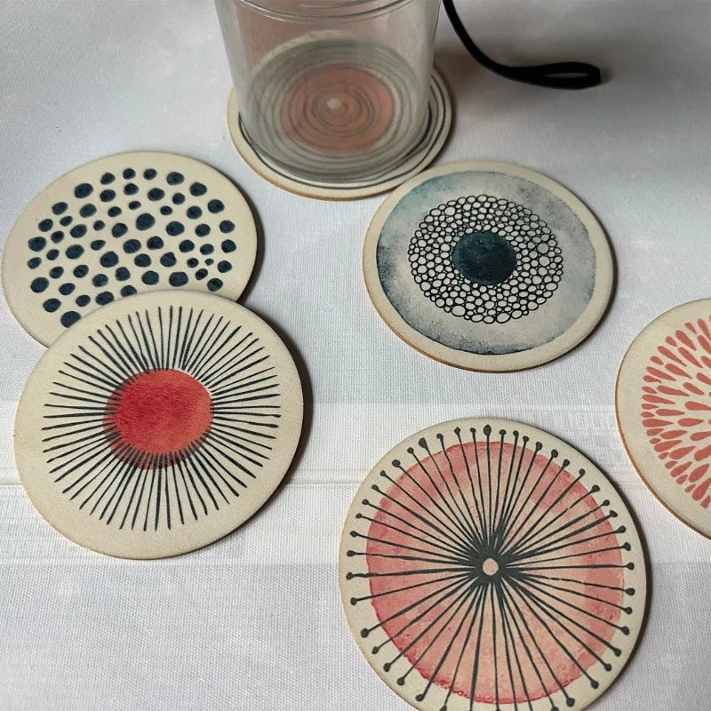 Set of round coasters with artistic designs on a white surface