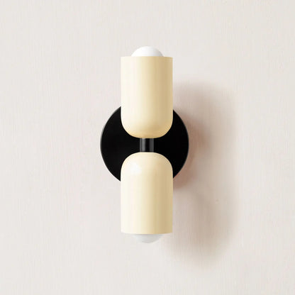 Modern wall sconce with beige and black design on a light gray background