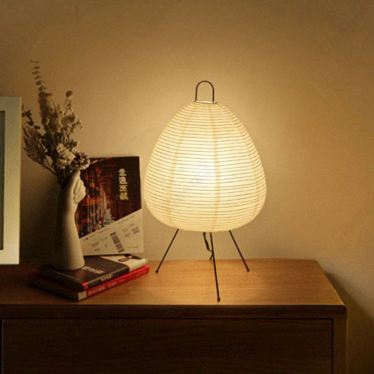 Table lamp with woven design on a wooden surface, emitting warm light.