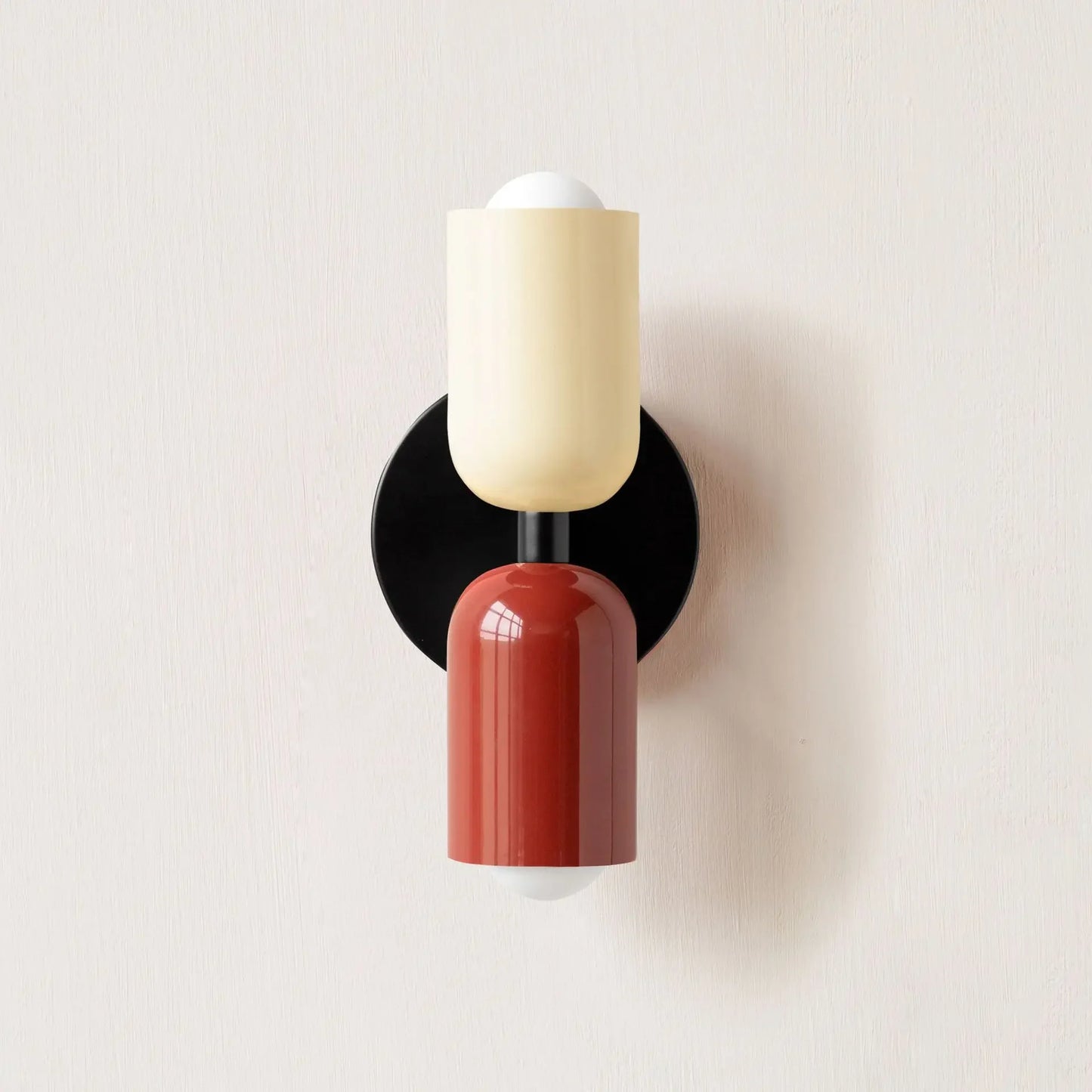 Wall sconce with black, beige, and red design on a light gray background