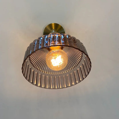 Ceiling light fixture with a metallic finish on a plain background