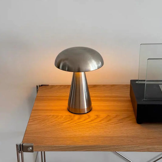 Metallic lamp on a wooden desk with a neutral background