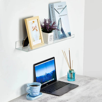 Clear acrylic shelf in an office above a laptop on a grey table