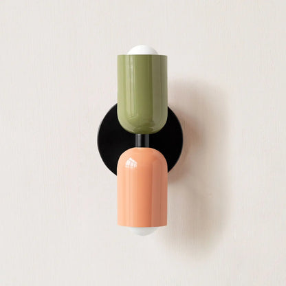 Wall-mounted light fixture with green and peach-colored design on a white background