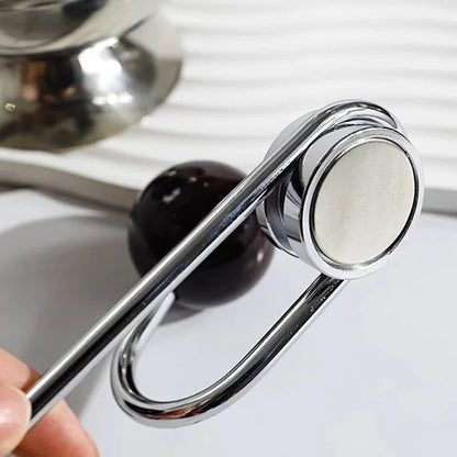 Metallic object with a circular component held by a hand.