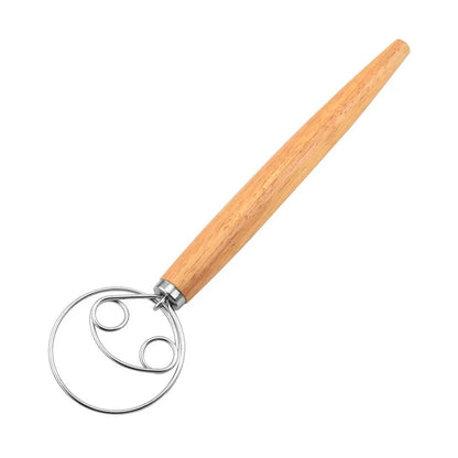 Wooden-handled dough whisk on a white background