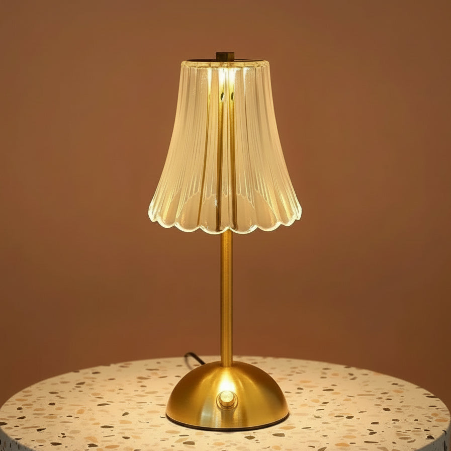 A fluted glass table lamp on a terazzo surface.