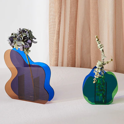 Two blue vases of different shapes on a white table with beige curtains behind