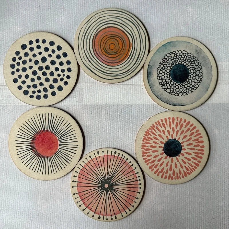 Set of six circular coasters with various patterns on a light gray background
