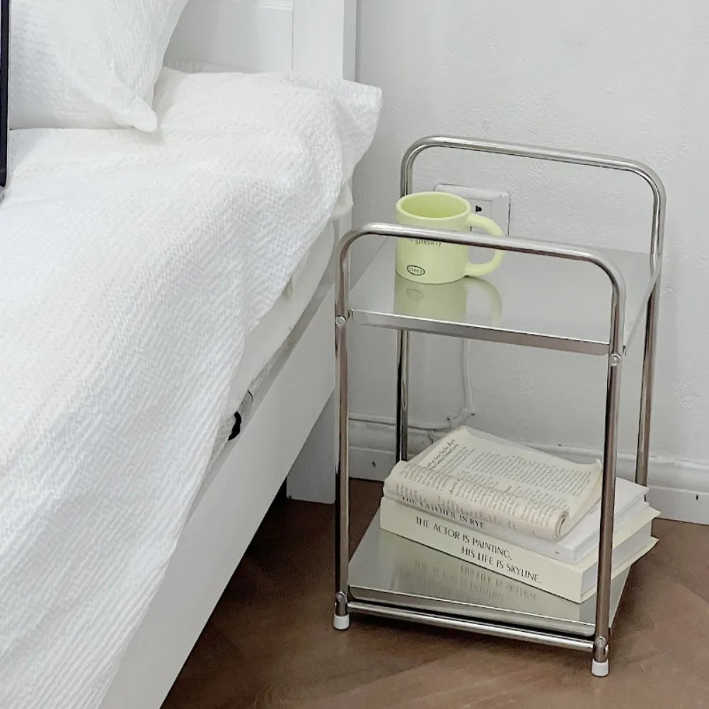 A metal trolley cart with storage, used as a bedside table 