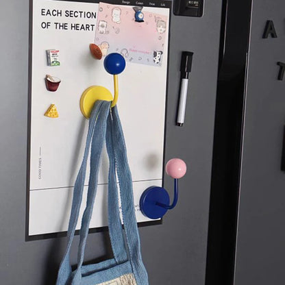 Colorful hooks on a refrigerator with a bag and paper attached