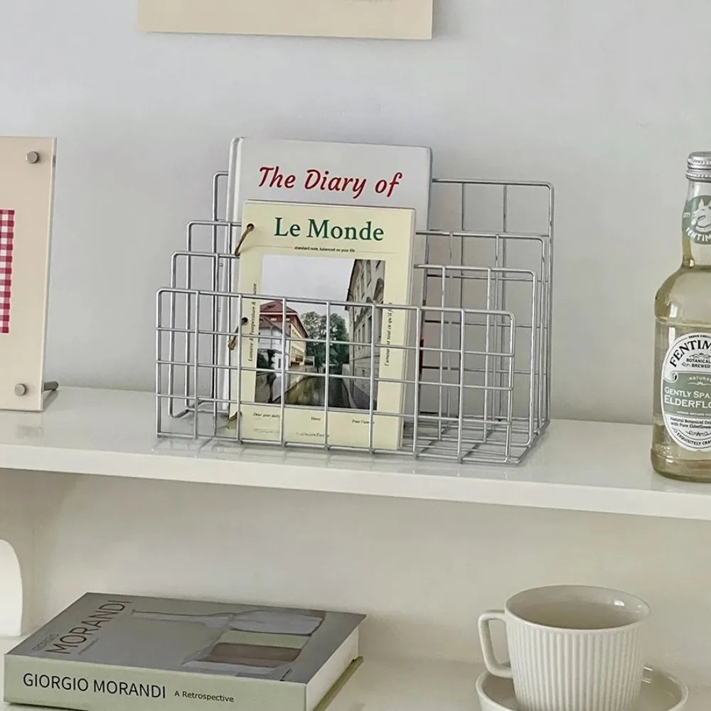 Wire magazine holder with books on a shelf next to a bottle of Pimm's.