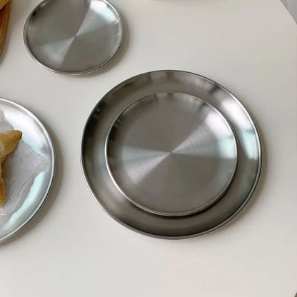 Stainless steel plates on a white surface