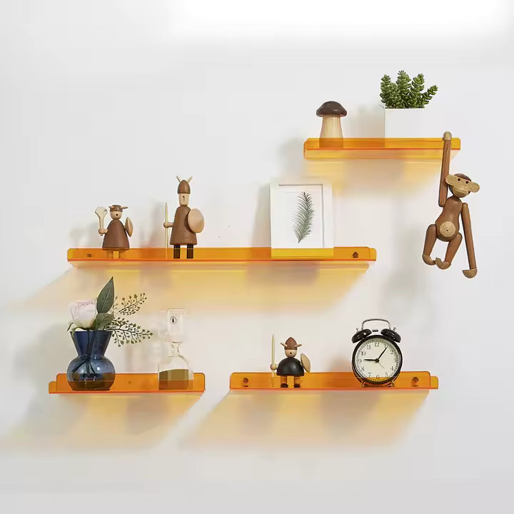 Set of orange shelves with decorative items on a white wall