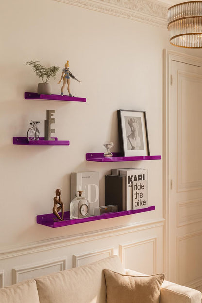 Purple shelves with decorative items on a wall above a sofa