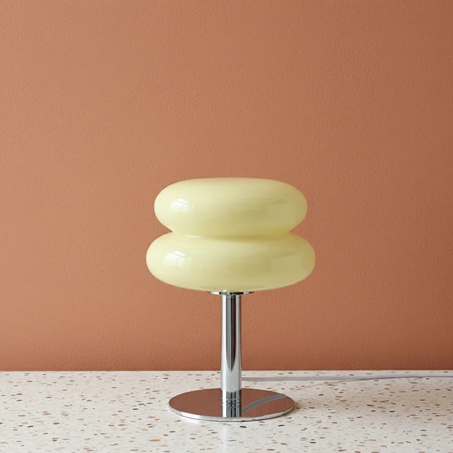 Cream light with a metallic base on a terrazzo surface against a peach wall.