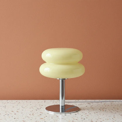 Cream light with a metallic base on a terrazzo surface against a peach wall.