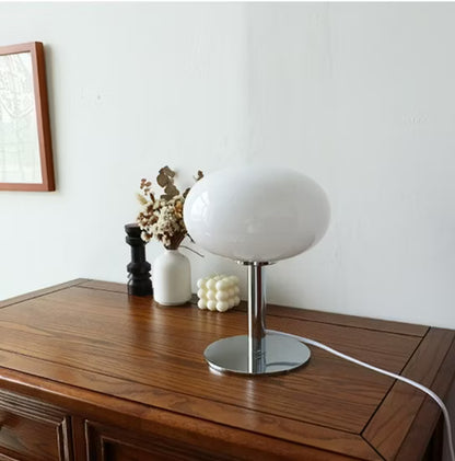 White table lamp on a wooden surface with a minimal background