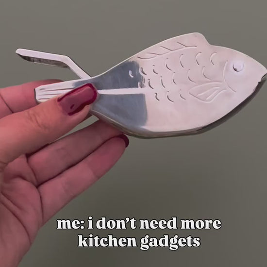 A video of a fish shaped metal lemon juicer in different settings and then being used to flavour a spaghetti dish. 