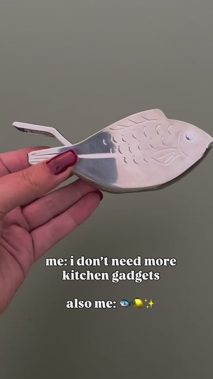 A video of a fish shaped metal lemon juicer in different settings and then being used to flavour a spaghetti dish. 