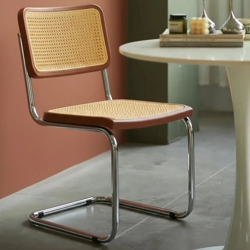 Chair with wicker seat and backrest in a room with a table and decor items.