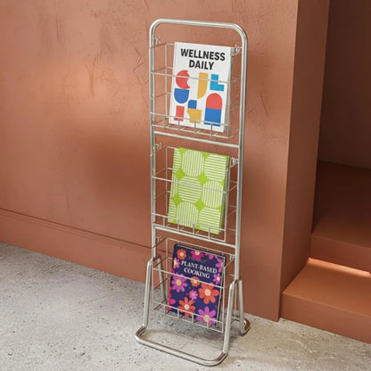 Metal magazine rack with books on a brown wall background